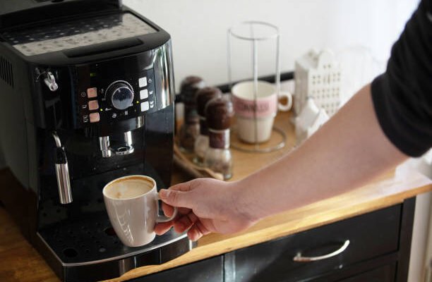 "Keurig coffee maker: Sleek black model with illuminated buttons and a clear water reservoir on the side."