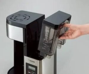 "Open electric coffee maker ready for cleaning"