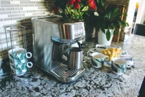 Breville Bambino Plus next to a fresh latte