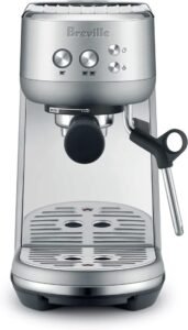 "A compact brushed stainless steel espresso machine designed for home use. It features a steam wand for frothing milk and manual espresso shot controls."