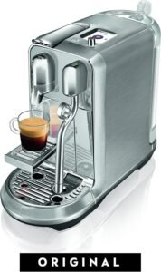 "A brushed stainless steel Nespresso machine with a built-in milk frother. It features multiple beverage settings and a sleek, modern design."