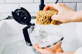 Rinsing cold brew carafe under hot water