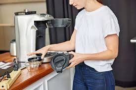 Adding vinegar solution during programmable coffee maker descaling process.