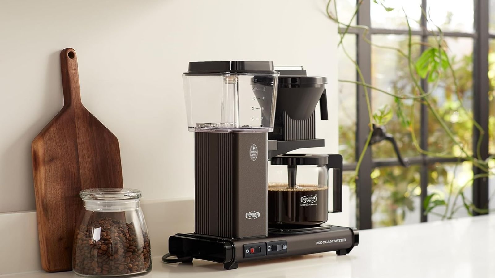 Drip coffee maker alongside French press and espresso machine for comparison.