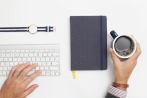 Image  of a person doing offive work having a cup of coffeee.