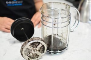 Maintain your French press coffee maker on kitchen counter with coffee beans”