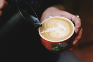 image of a mug filled with espresso filling a cup.